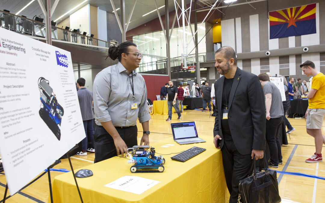 A student chats with an attendee at the 2023 fall innovation showcase.